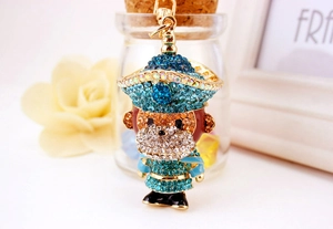 Détail d'un porte-clés singe mignon avec des strass étincelants et des vêtements bleus