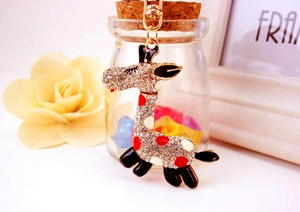 Détails d'un porte-clés girafe doré scintillant avec strass et accents en émail coloré