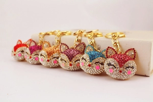 Close-up of sparkling rhinestone fox keychains in multiple colors with golden clasps