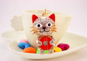 Detail of crystal studded lucky cat keychain with red coin and gold alloy plating