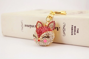 Close-up of sparkling rhinestone fox keychain with gold metal base and red crystal details