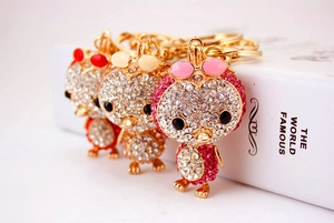 Macro shot of owl keychains with sparkling rhinestones in pink, white, and red colors
