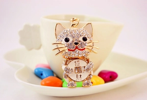 Macro shot of gold crystal lucky cat keychain with sparkling rhinestones and charm