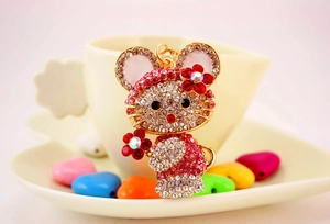 Dettaglio del portachiavi a coniglio con strass luccicanti e decoro floreale rosa su oro