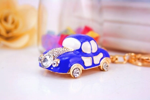 Macro shot of blue enamel car keychain with sparkling rhinestones and golden ring detail