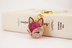 Close-up of sparkling rhinestone fox keychain with pink crystals and golden metal clasp