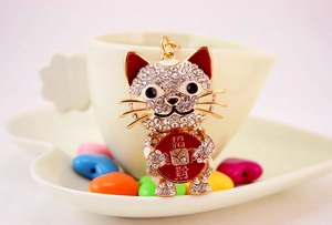 Detail of crystal studded lucky cat keychain with red enamel ears and golden招财 plaque