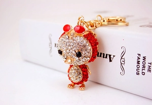Macro shot of sparkling red and white rhinestones on a golden duck keychain accessory