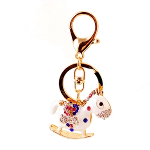 Cute golden rocking horse keychain with white enamel and colorful sparkling rhinestones