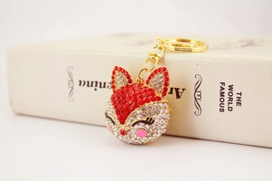 Close-up of luxury fox keychain with red and white rhinestones on golden metal base