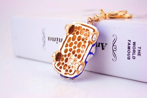 Detailed bottom view of a car keychain with colorful rhinestones and gold metal finish