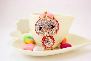 Detailed macro view of the sparkling rhinestone-encrusted duck keychain and golden metal base