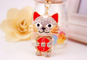 Detail of crystal-encrusted Maneki Neko keychain with red enamel and gold finish