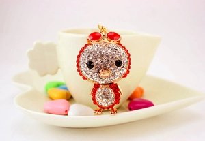 Close-up of duck charm keychain with white and red rhinestones and golden metal hook