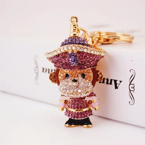 Porte-clés singe du zodiaque orné de strass violets et roses sur support en métal doré