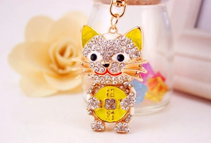 Macro detail of golden crystal lucky cat keychain with sparkling rhinestones for bags