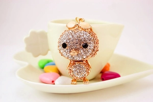 Detailed view of a sparkling crystal duck keychain hanging on a beige coffee cup