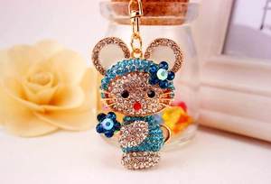 Dettaglio del ciondolo a forma di gatto in metallo dorato con strass blu e fiori