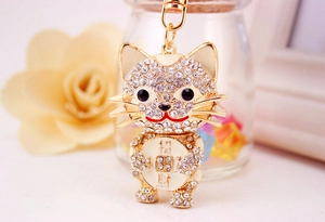 Detailed close-up of golden Maneki-Neko keychain with sparkling white rhinestones