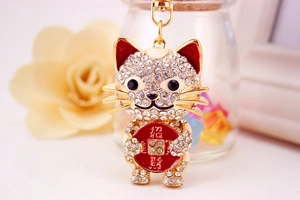 Detailed close-up of lucky cat keychain with sparkling crystals and golden metal