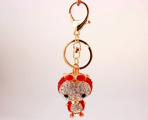 Macro view of gold-plated duck keychain with sparkling red and white rhinestones