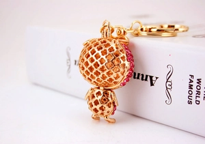 Detailed macro of golden owl keychain with pink rhinestones and a polished key ring