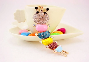 Detailed view of a colorful caterpillar keychain with rhinestones and enamel on a cup