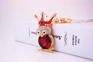 Détail du porte-clés hibou avec ventre en pierre rouge et couronne en strass avec crâne