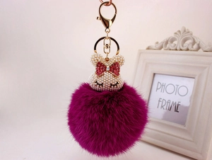 Détail de boule de fourrure violette avec tête de lapin perle et porte-clé doré