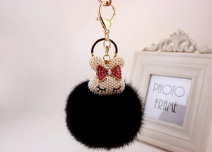 Détail d'un porte-clés lapin en fausse fourrure noire avec tête en perles et nœud
