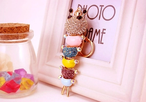 Detailed macro view of a colorful caterpillar keychain with sparkling rhinestones and gold ring