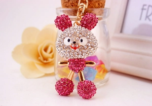 Detailed macro shot of a handmade rhinestone rabbit keychain with golden metal clasp