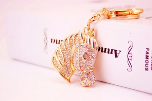 Detailed close-up of sparkling rhinestone horse head keychain in golden alloy finish