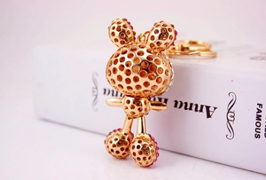 Detail of a golden rabbit keychain with sparkling pink rhinestones and hollow design