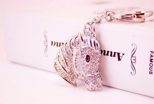 Close-up of a silver horse head keychain with sparkling rhinestones and rotating hook