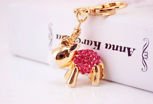 Macro shot of cute golden lamb keychain with pink rhinestones and durable gold-tone metal hook