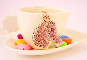 Close-up of golden horse head keychain with sparkling rhinestones and metal ring