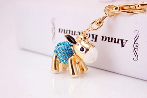 Detailed close-up of a golden cartoon donkey keychain with sparkling blue rhinestones