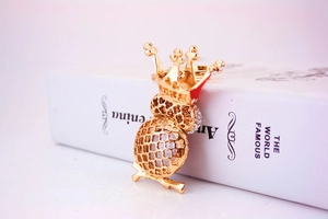 Détail d'un porte-clés chouette dorée avec couronne et décorations en strass brillants