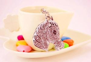 Close-up of a silver horse head keychain pendant with sparkling rhinestones details