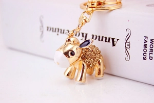 Detail of golden donkey keychain with coffee crystals and lobster clasp on a book