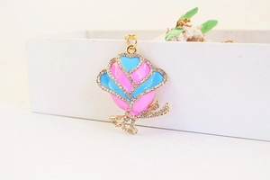 Close-up of rhinestone floral pendant with pink and blue enamel and gold-tone finish