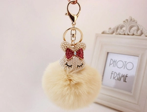 Détail du porte-clés lapin en perles avec pompon en fausse fourrure beige et clip doré