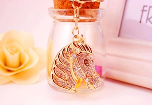 Macro shot of gold horse head keychain with sparkling rhinestones for car keys and bags