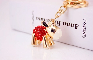 Close-up of golden donkey keychain with red rhinestones and lobster clasp detail