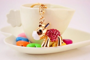 Close-up of a cartoon donkey keychain with pink rhinestones and a gold lobster clasp