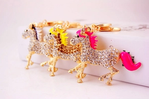 Detail of horse-shaped keychains with sparkling rhinestones in pink, yellow, and purple