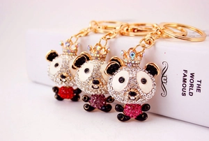 Macro shot of sparkling crystal bear keychains with golden crowns in three vibrant colors
