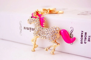 Close-up of sparkling horse keychain with white rhinestones and pink enamel accents