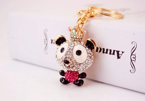 Macro view of gold-tone panda keychain with pink and white rhinestones and a crown